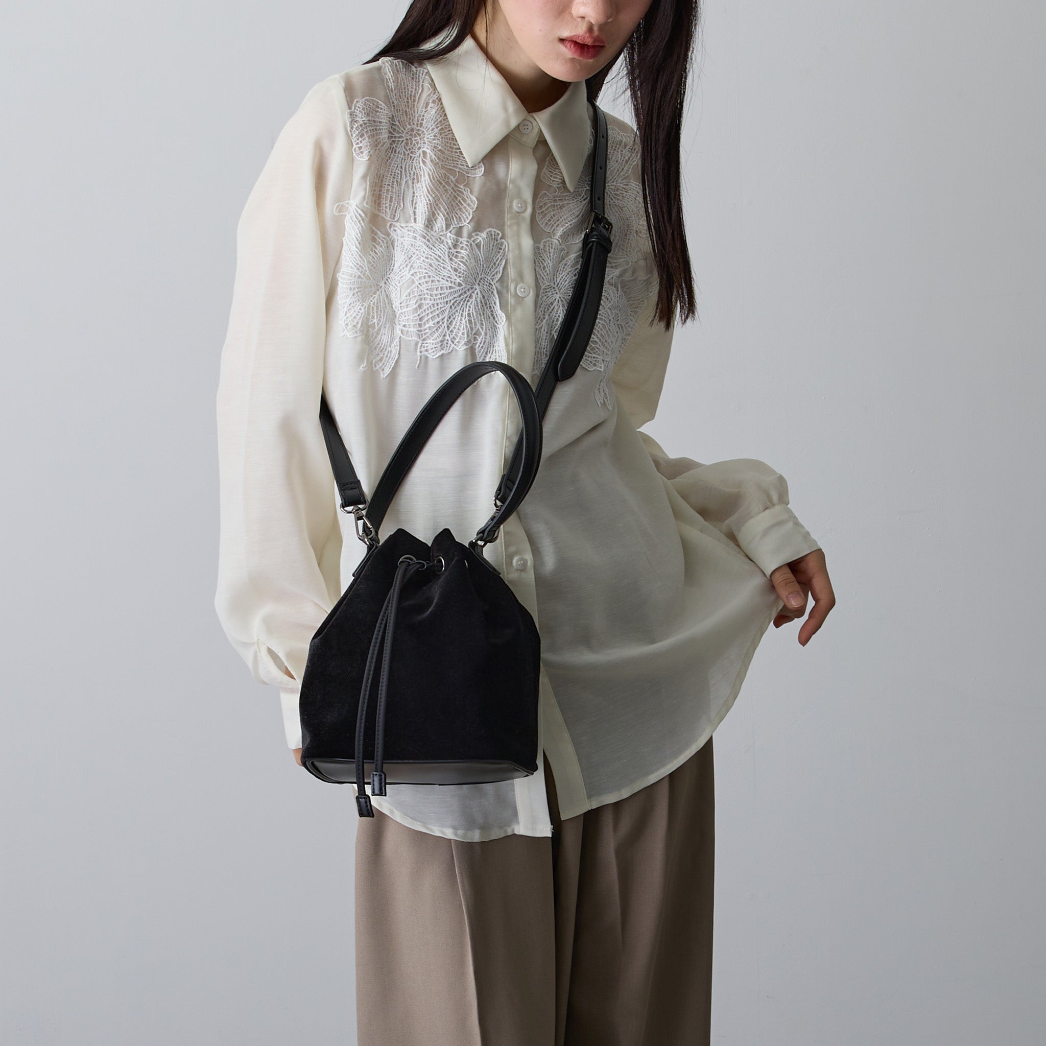 黒ベロア巾着バッグを肩掛けする女性 ナチュラルコーデ