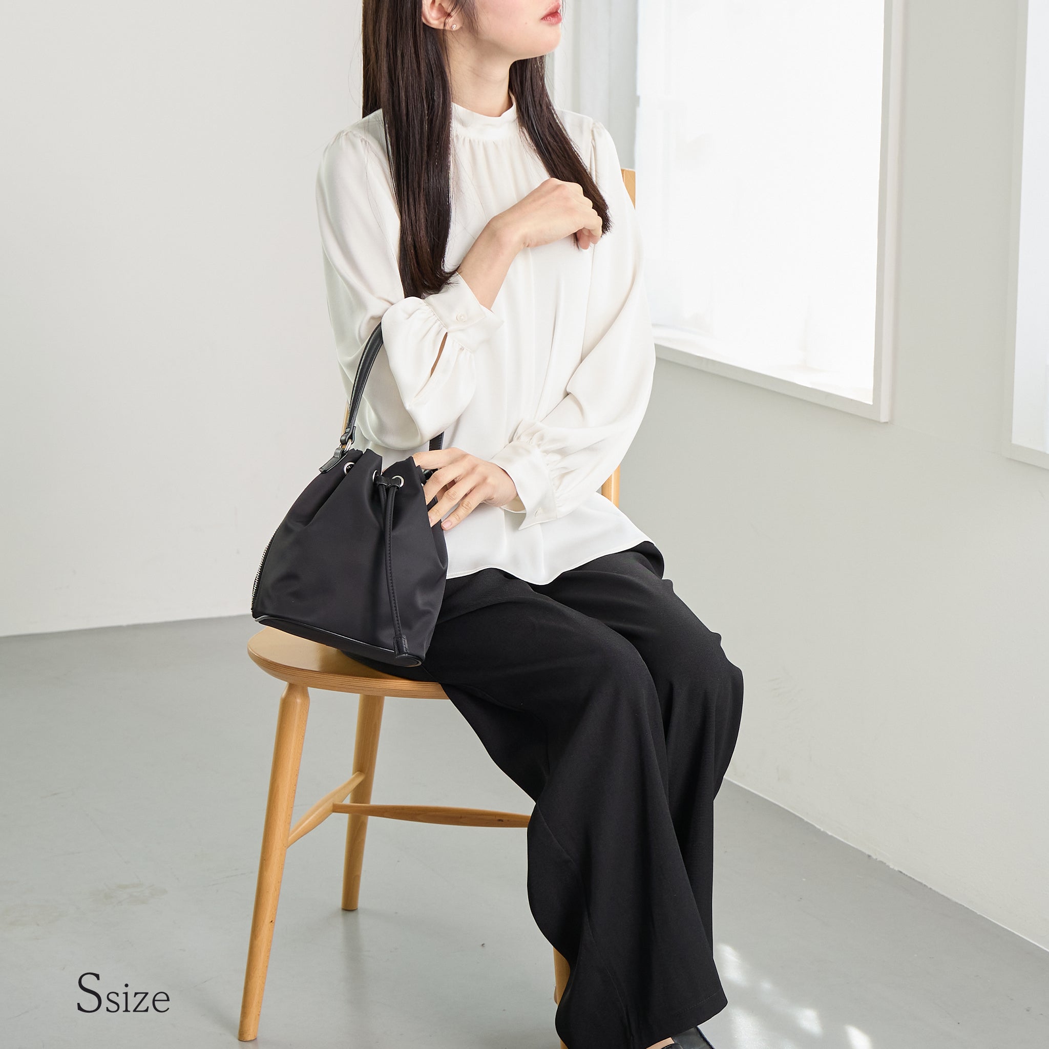 黒ナイロン巾着バッグSサイズを腕にかけた女性 ナチュラルスタイル