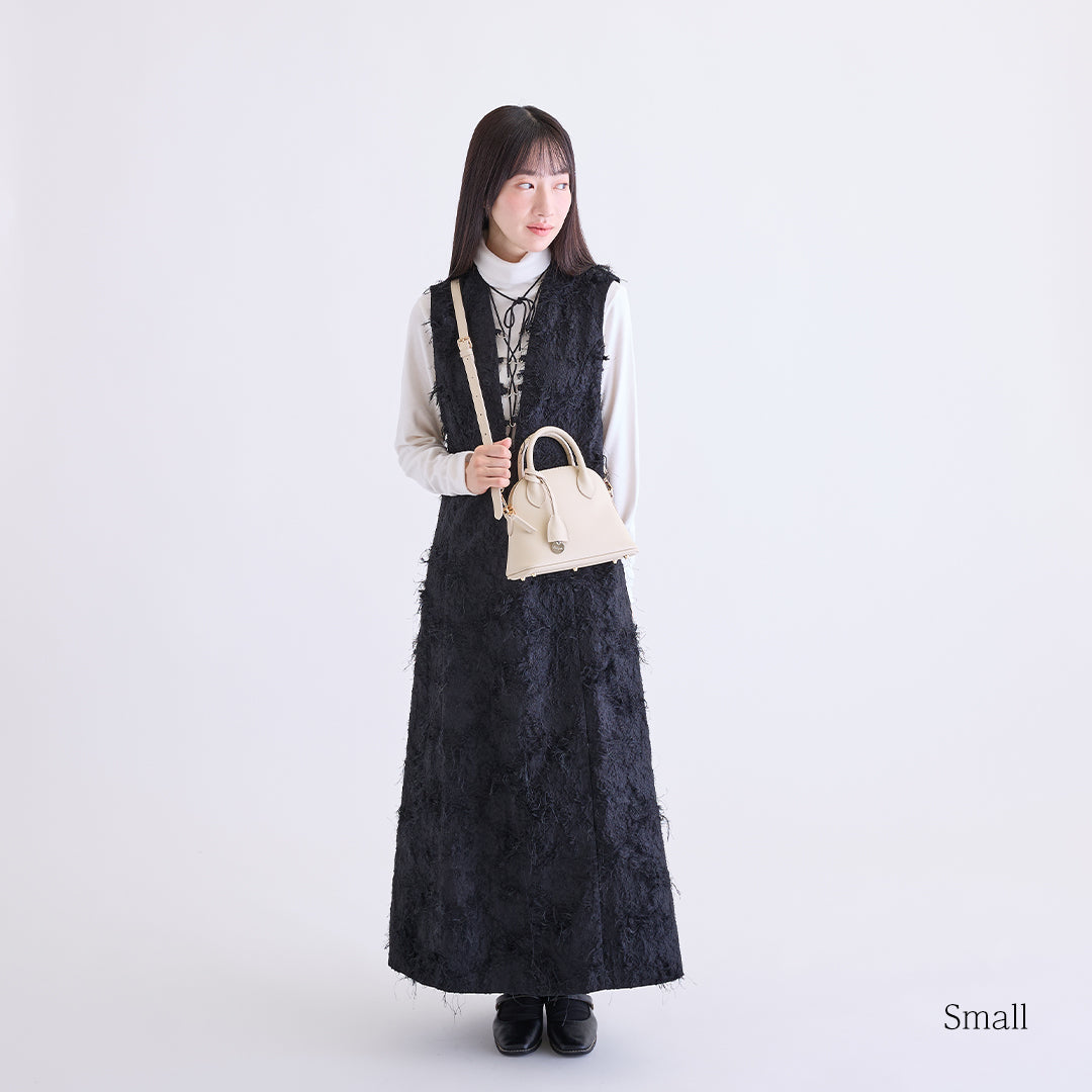 アイボリーのボストンバッグを肩掛けした女性