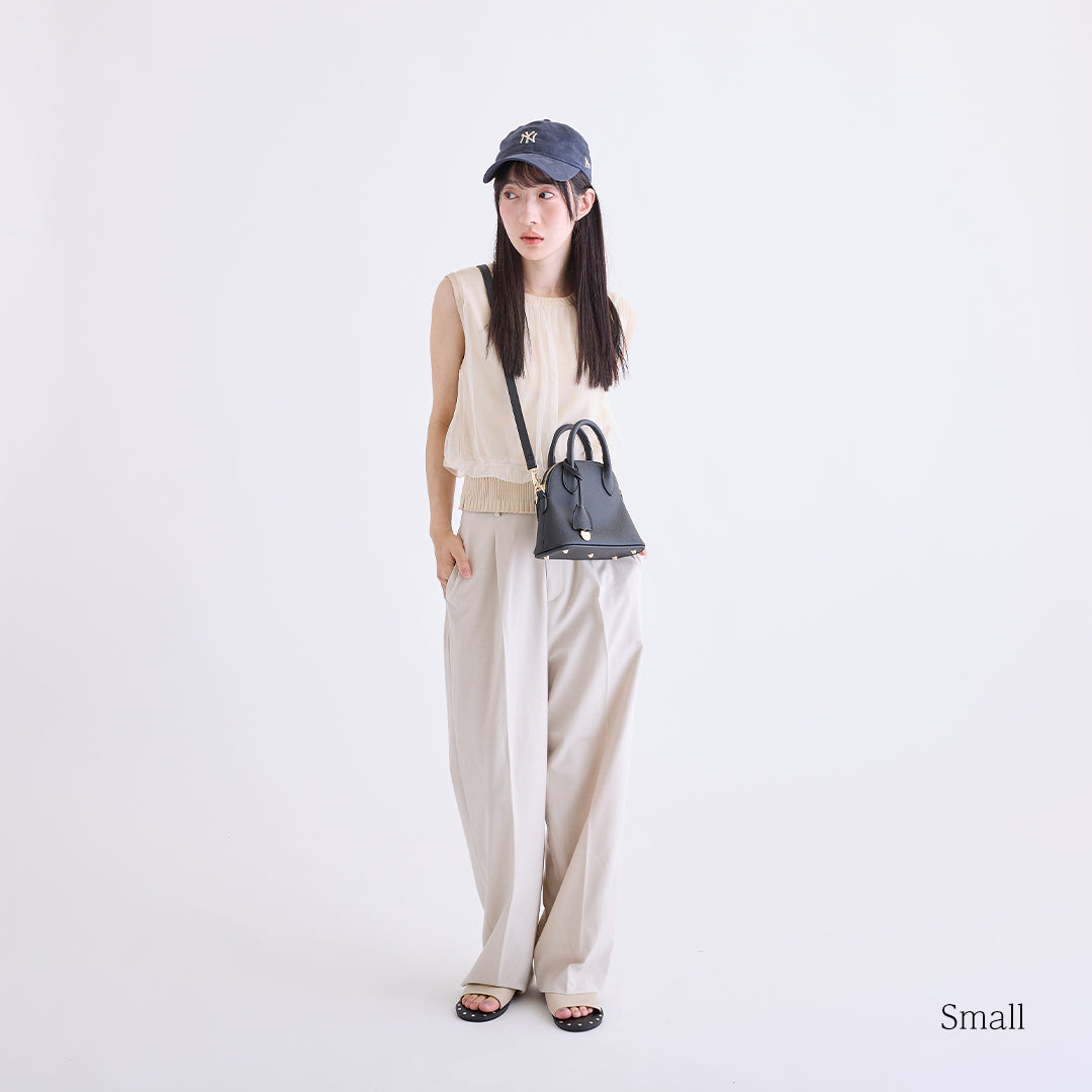 ブラックのミニボストンバッグを斜め掛けした女性